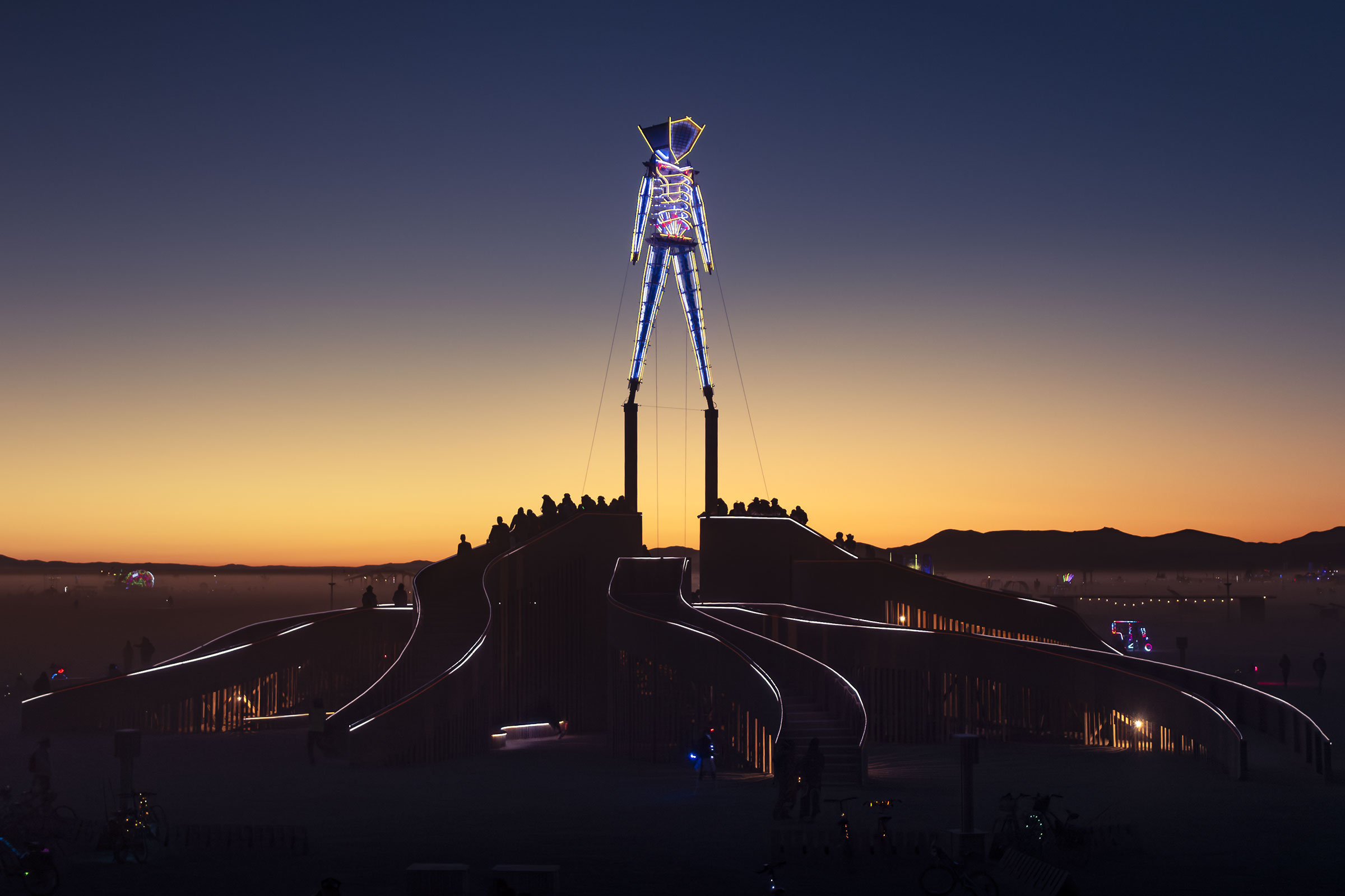 The sun rises behind the Man at Burning Man 2024. (Photo by Scott London)